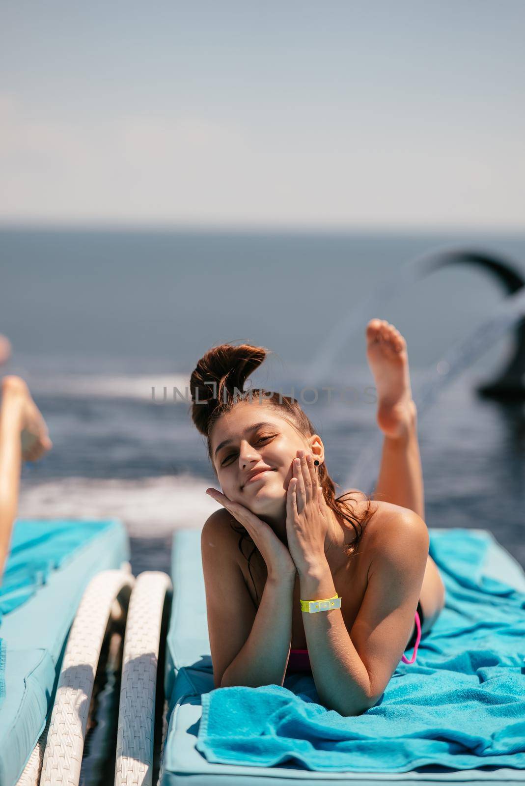 A young beautiful woman in swimsuit sunbathes on a sun lounger by the pool at the hotel.Summer concept.