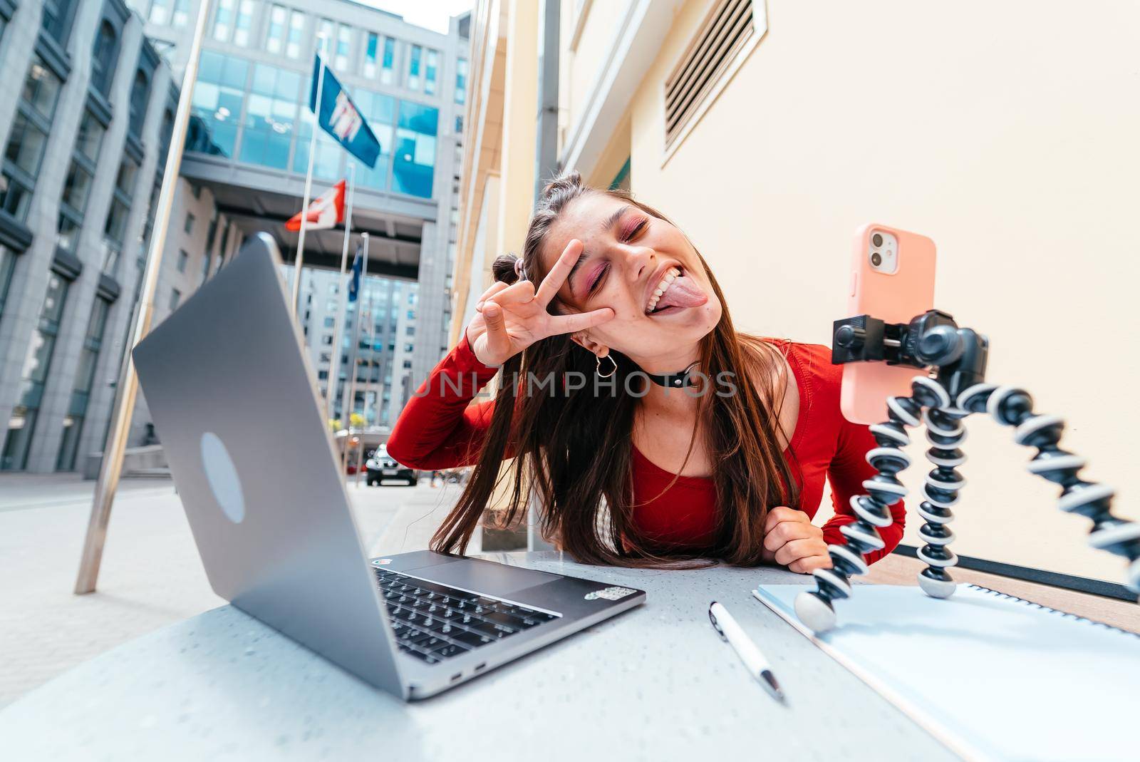 Young woman in a summer cafe doing remote work. Freelancer woman. Small business