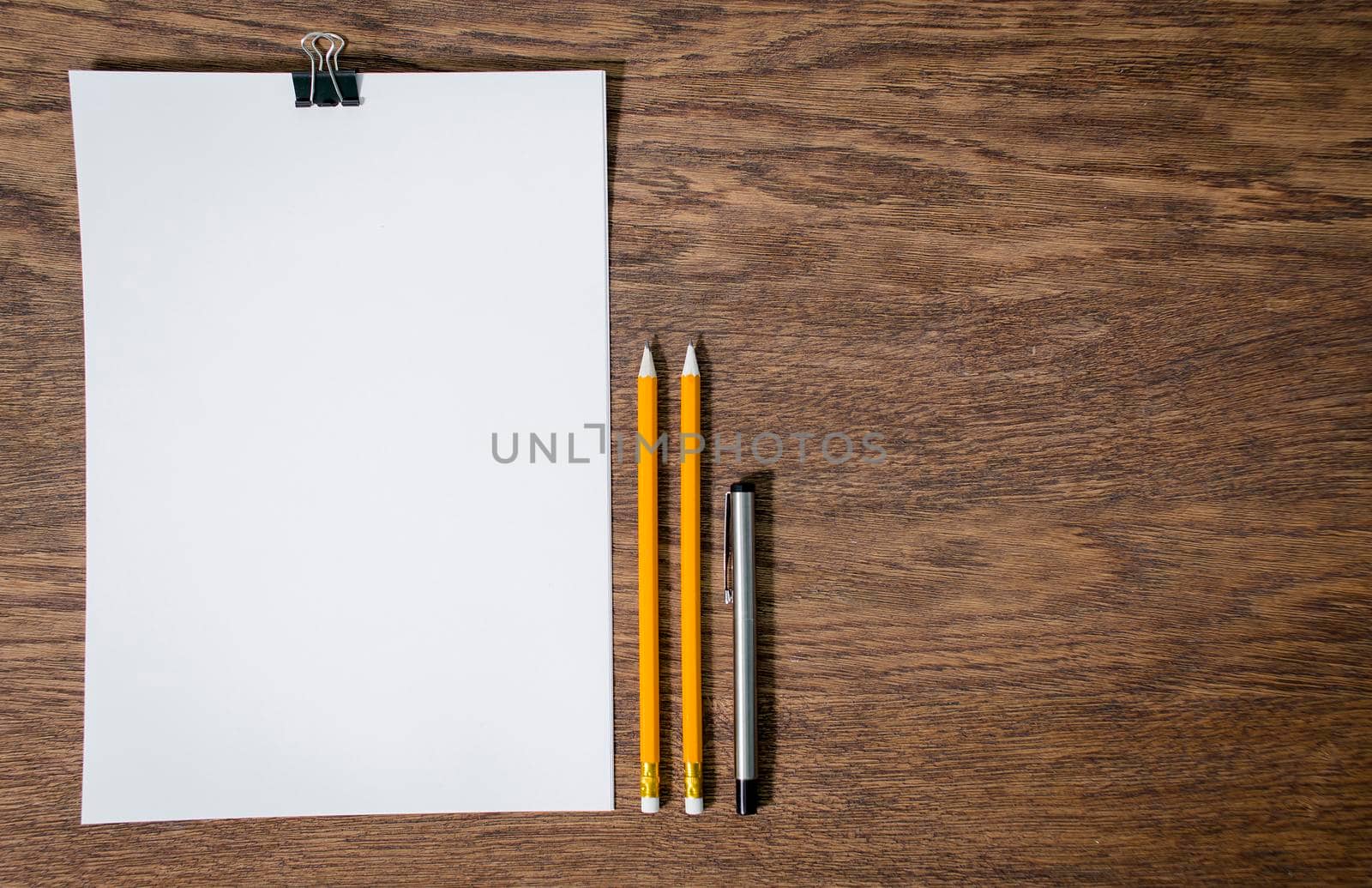 Paper and pencils on the wooden table. close-up.
