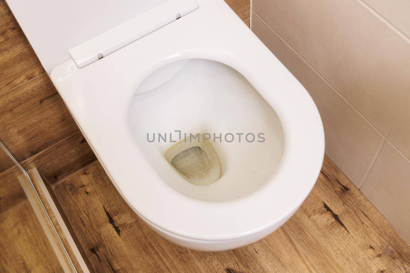 Dirty unhygienic toilet bowl with a lime stain in the toilet close-up by Ramanouskaya