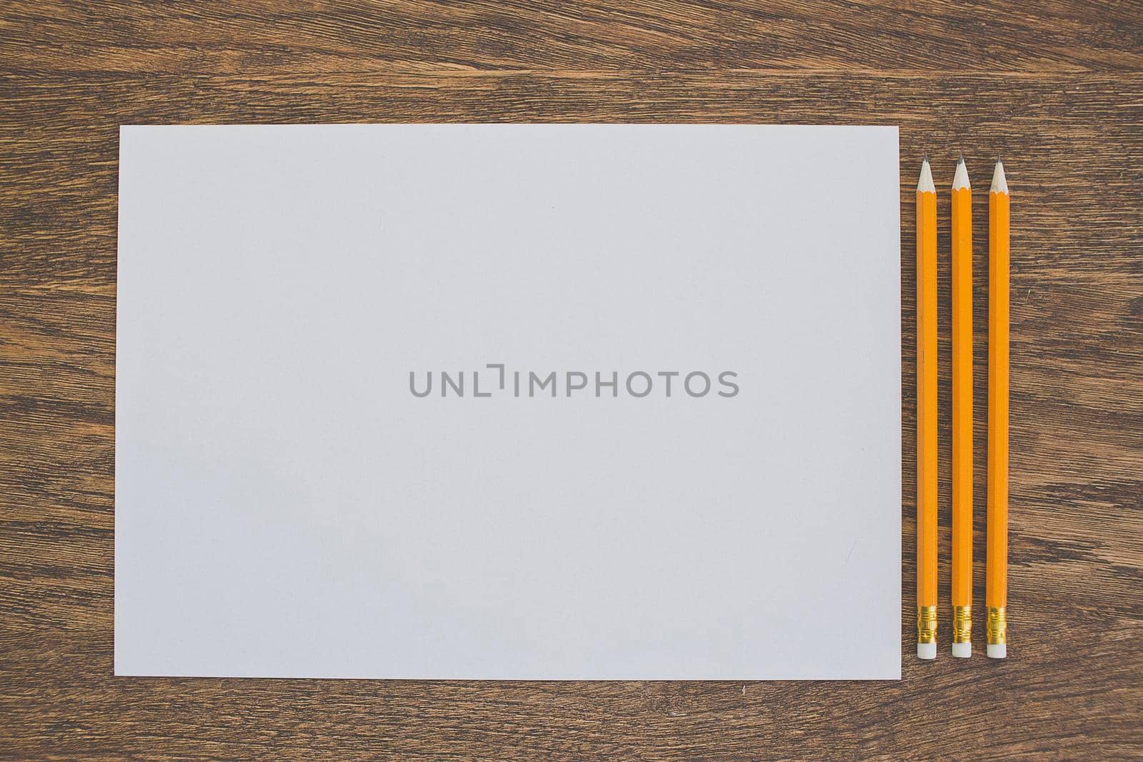 Paper and pencils on the wooden table. close-up.