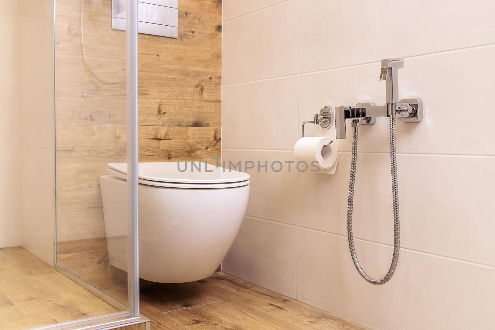 toilet and shower for bidet in the bathroom with ceramic tiles in natural colors by Ramanouskaya