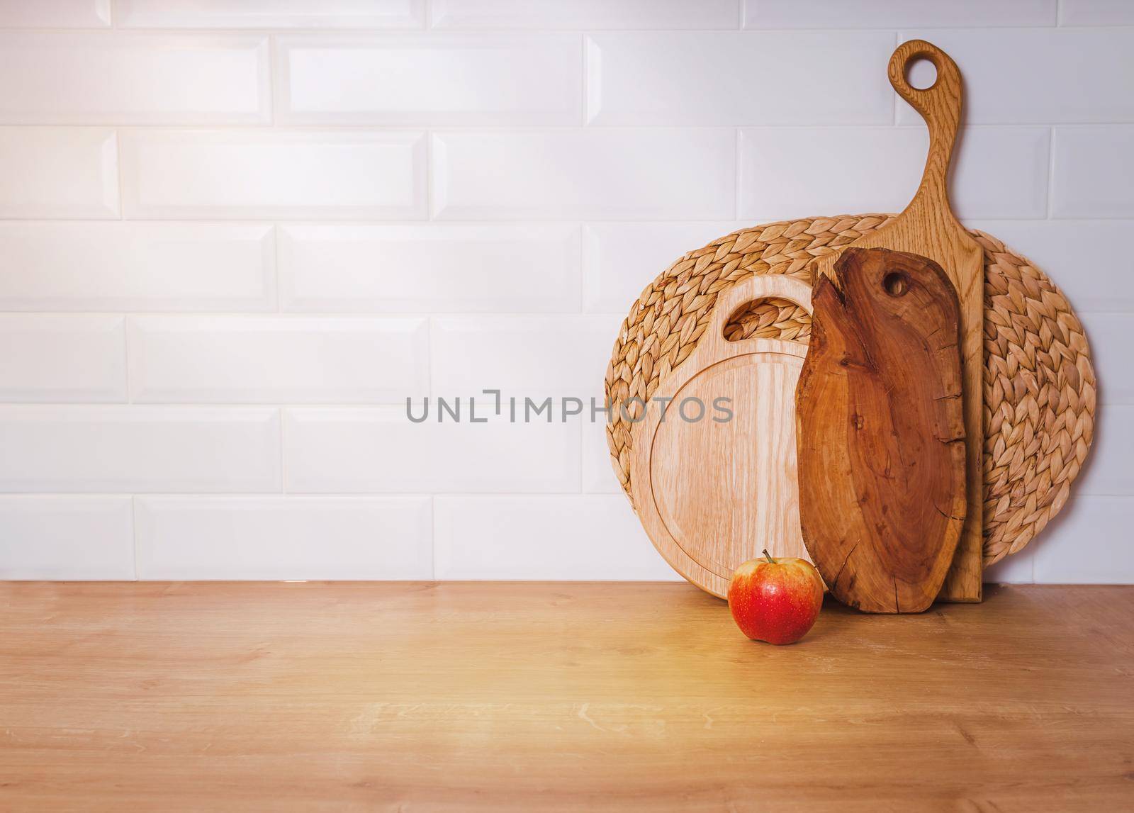 mockup, concept of old cuisine and scandinavian recipes. Vintage wooden cutting boards, white brick wall and red apple. Copy paste your design.