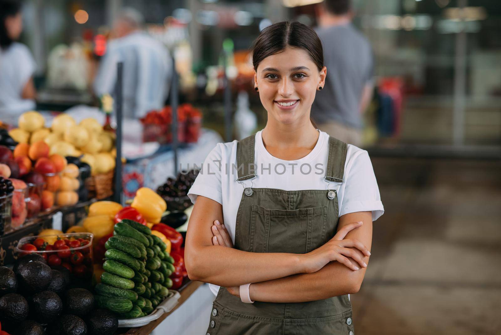 A woman seller of fruit at the market near the counter with fresh goods