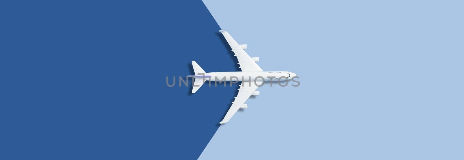 Flat lay of miniature toy airplane on blue background. High quality photo