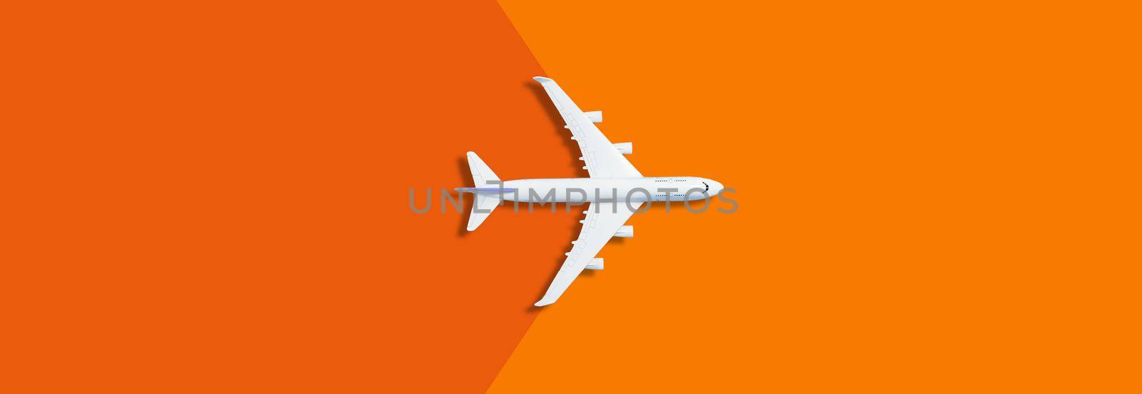 Flat lay design of travel concept with plane on yellow, orange background with copy space. High quality photo