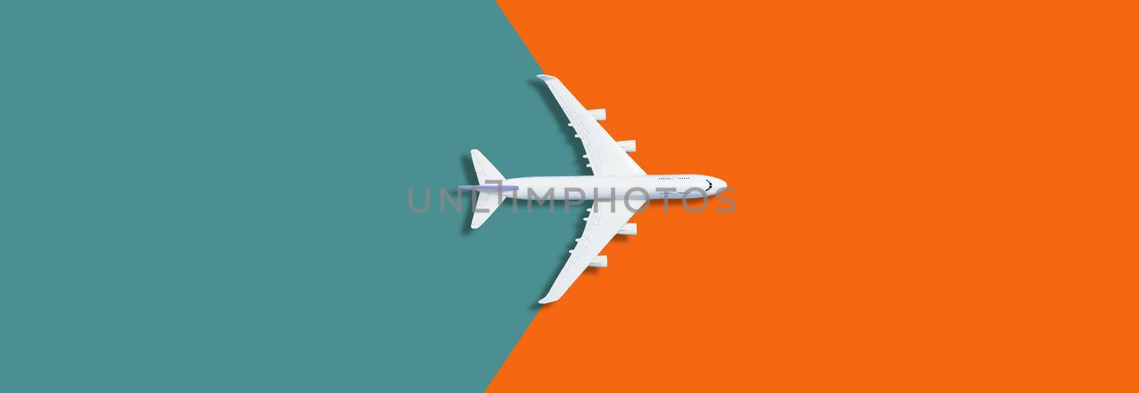 Flat lay design of travel concept with plane on orange background with copy space. High quality photo