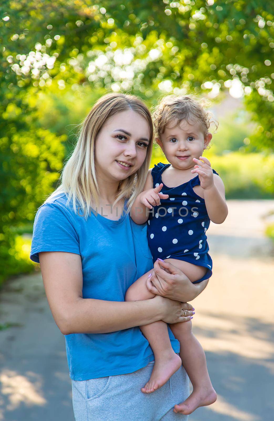 Mother in the park with a child in her arms. Selective focus. by yanadjana