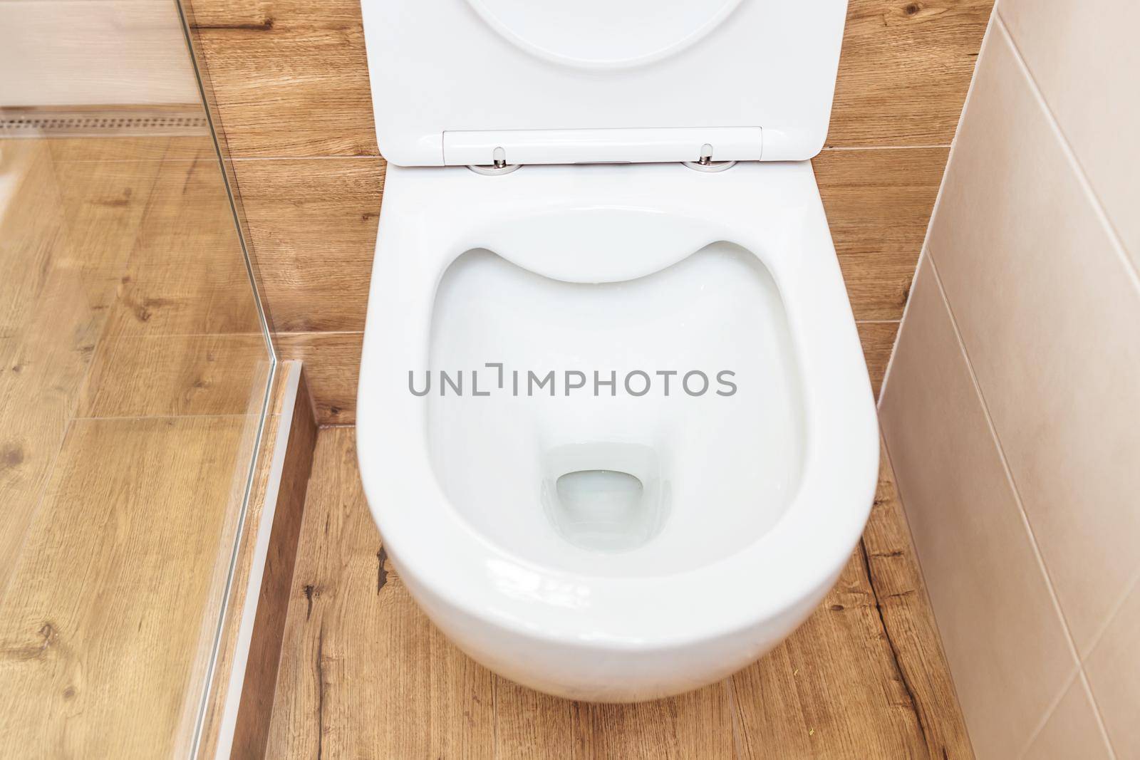 Clean toilet bowl with open lid in toilet, hygiene concept. View from above. by Ramanouskaya