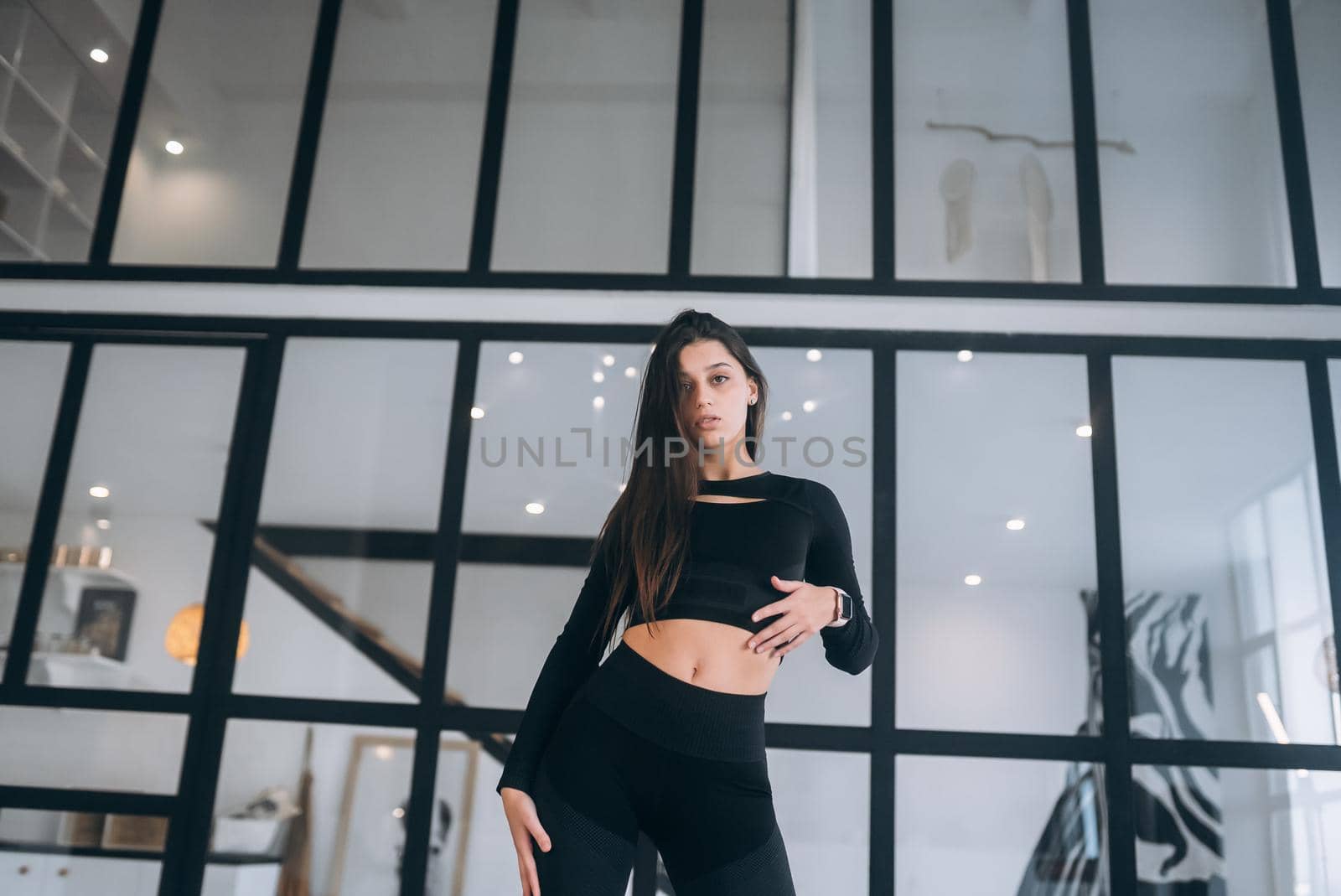 Photo of adorable pretty young girl dressed sport suit practicing aerobics smiling indoors house home