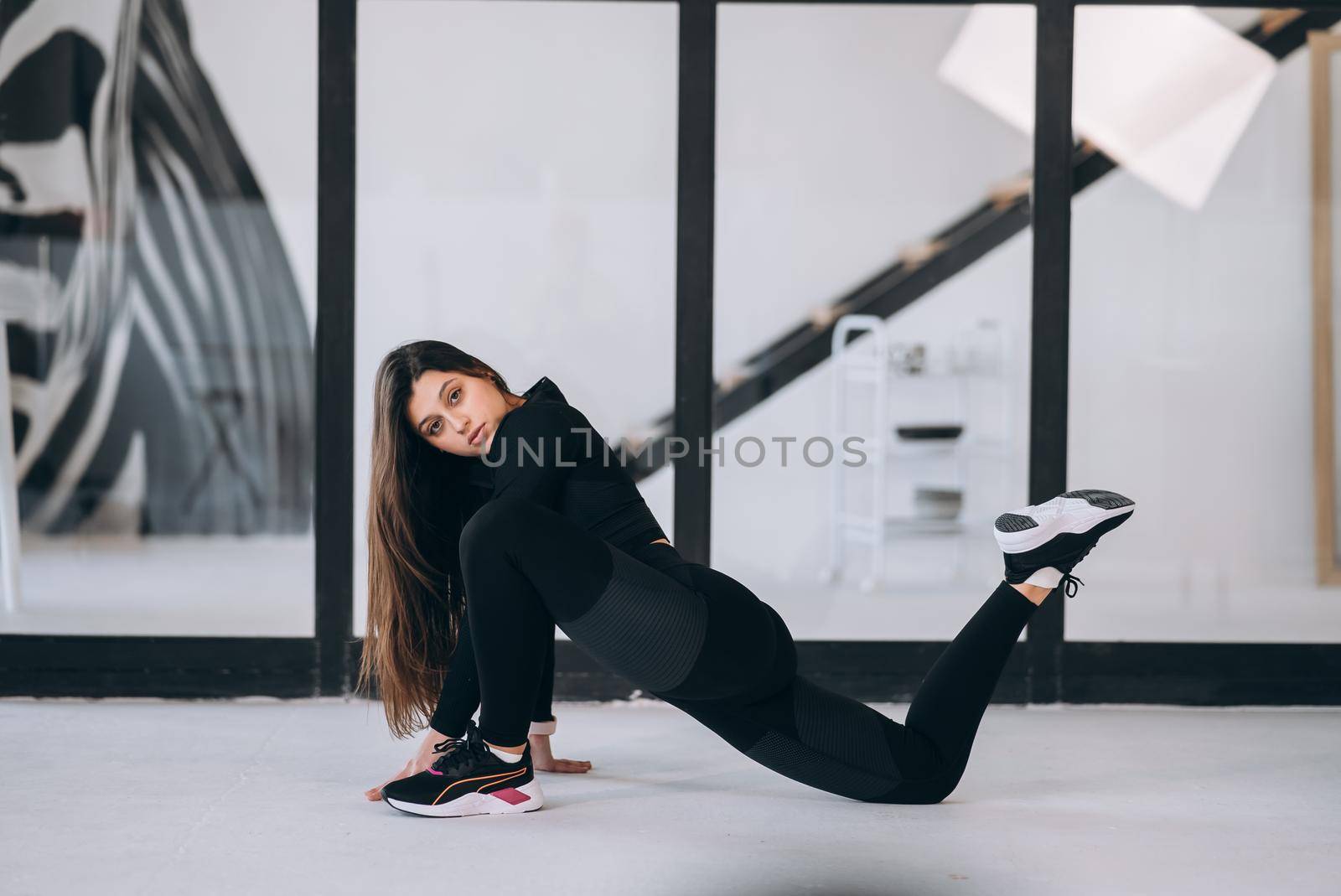 Side view of flexible girl exercising yoga pose indoors. Concept of yoga.