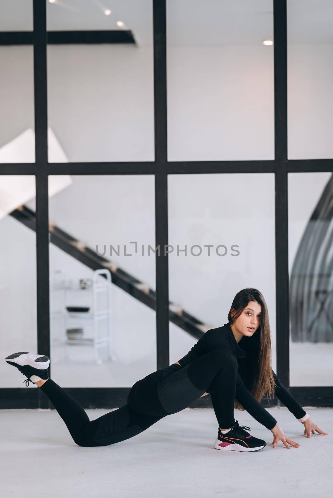 Side view of flexible girl exercising yoga pose indoors. Concept of yoga.
