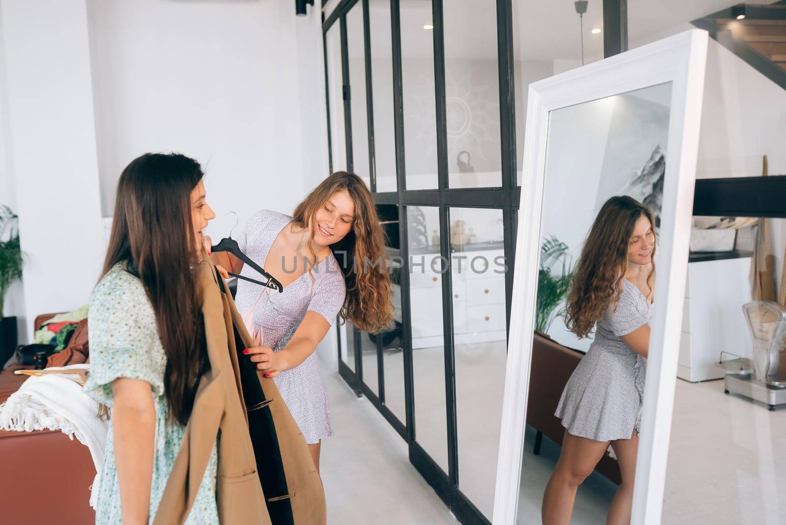 Image of pretty females trying on dress at home