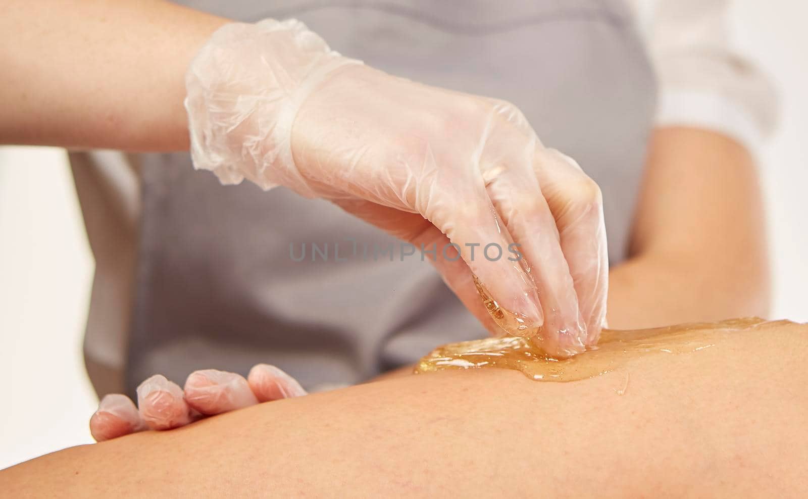 Sugar paste for light depilation. Depilation with sugar paste in the salon on a white background.