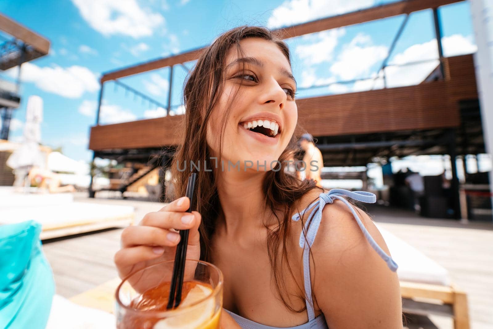 Pretty woman in bikini drinking cocktail at pool.