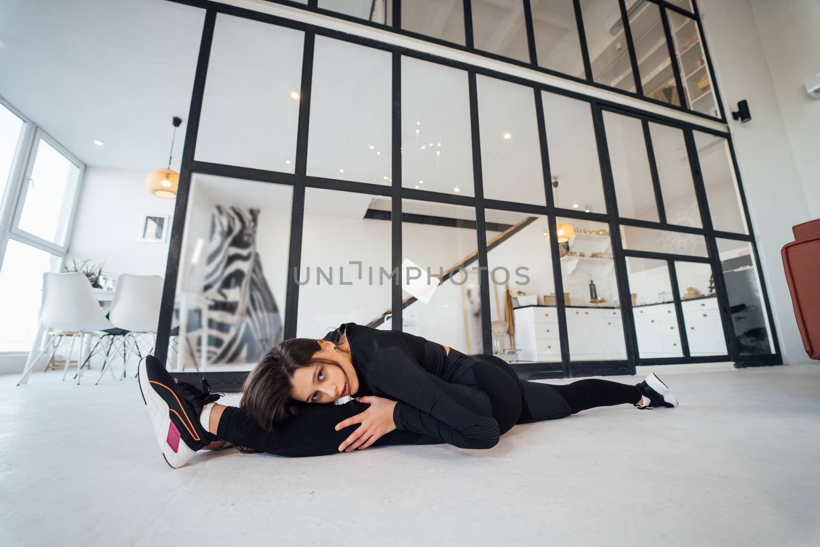 Side view of flexible girl exercising yoga pose indoors. Concept of yoga.