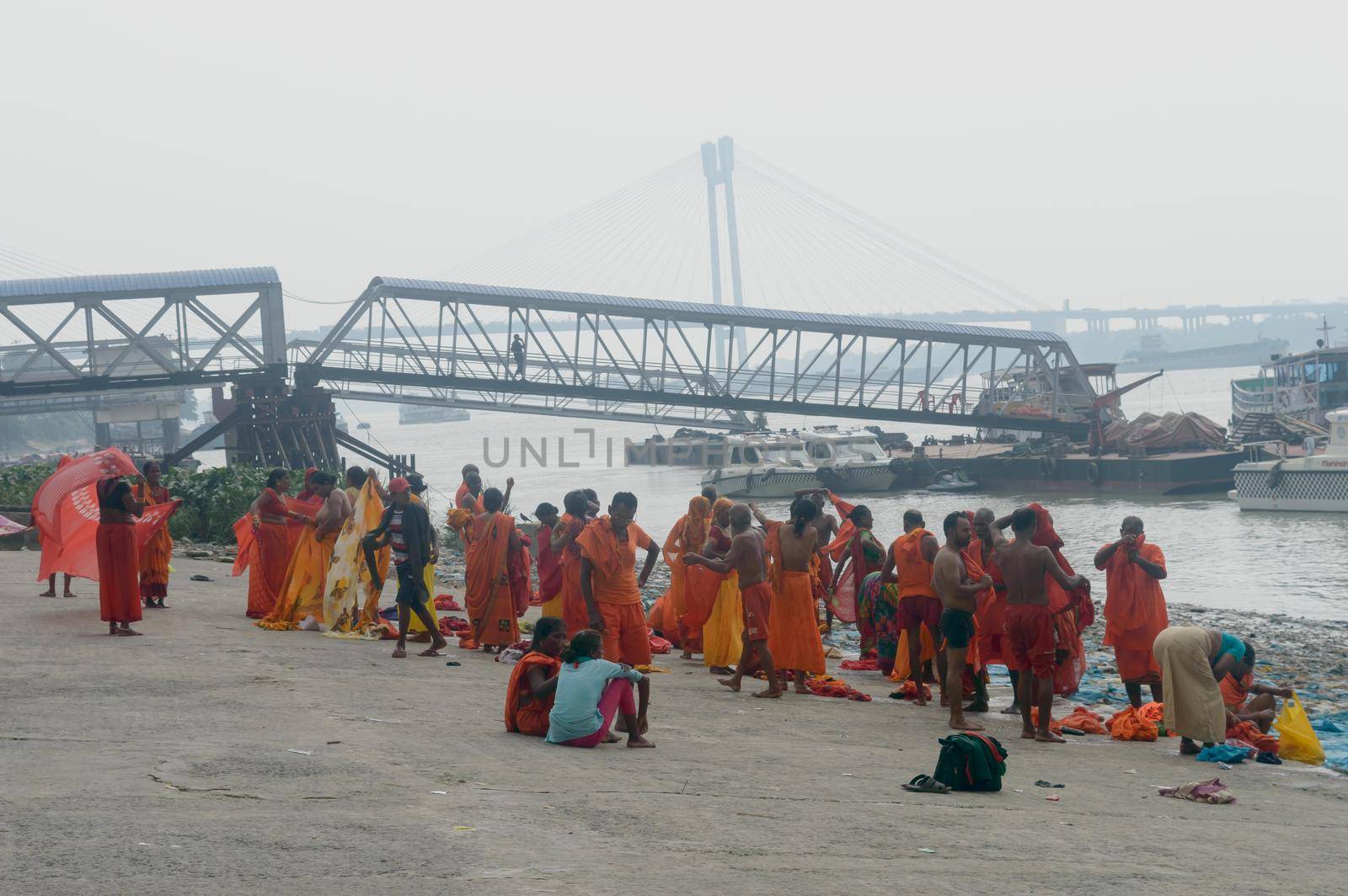 Pilgrim People are taking bath at the riverbank of the Ganges or river Hooghly . Babu Ghat, Kolkata, West Bengal, India. August 2, 2022