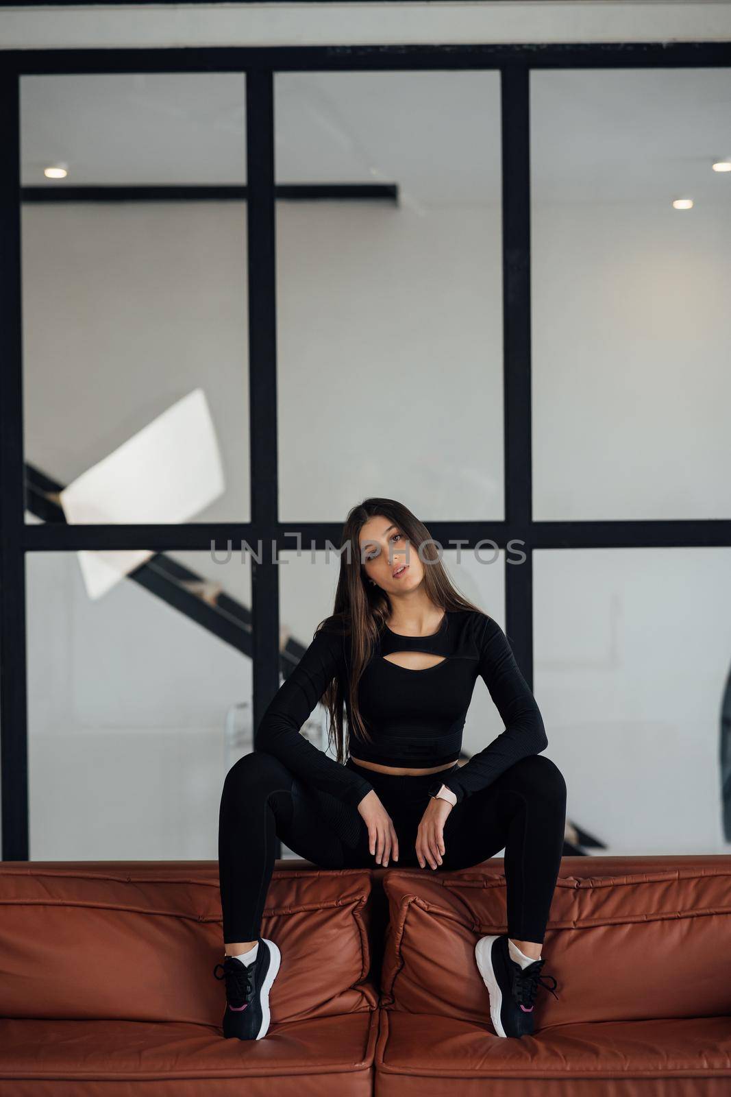 Pretty athletic girl sitting on sofa back