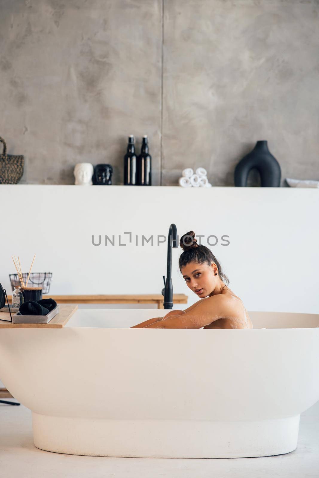 Pretty young woman taking bath at home