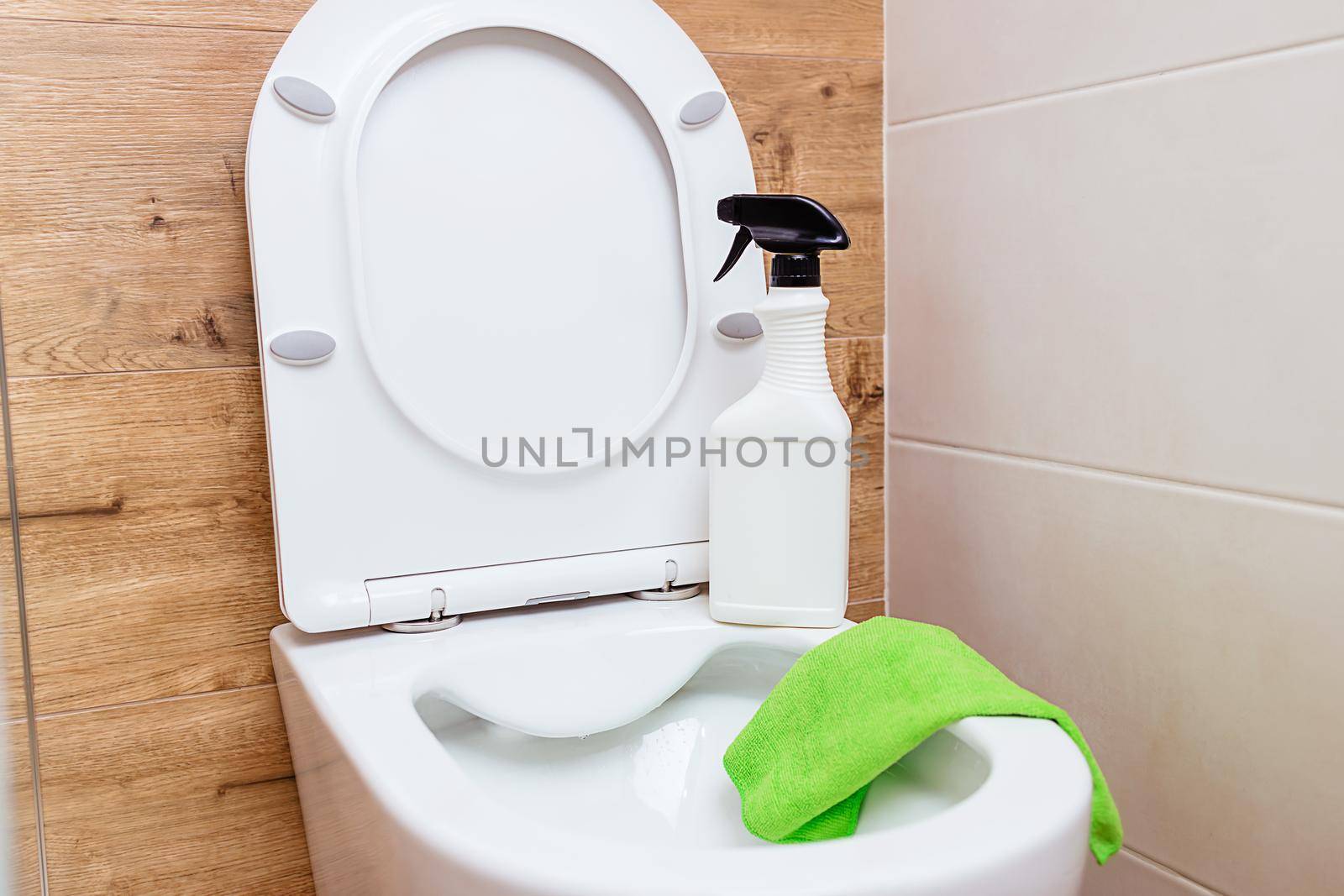 Mockup white detergent bottle, bathroom cleaning. Against the background of the toilet there is a jar of liquid, next to it is a rag, copy paste. Hygiene, cleaning and disinfection concept