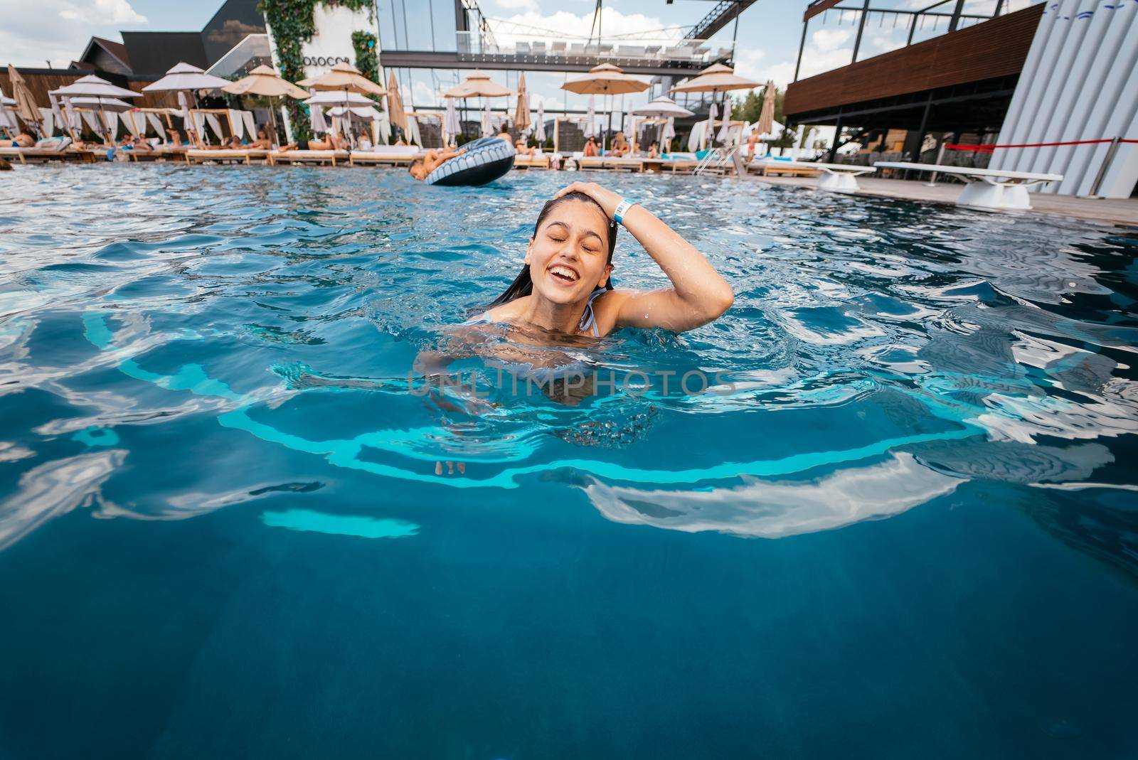 Young woman swimmer in blue pool water. Close view