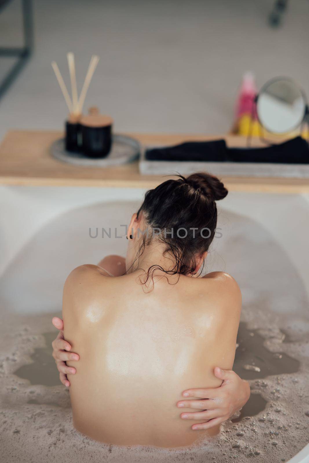 Pretty young woman taking bath at home