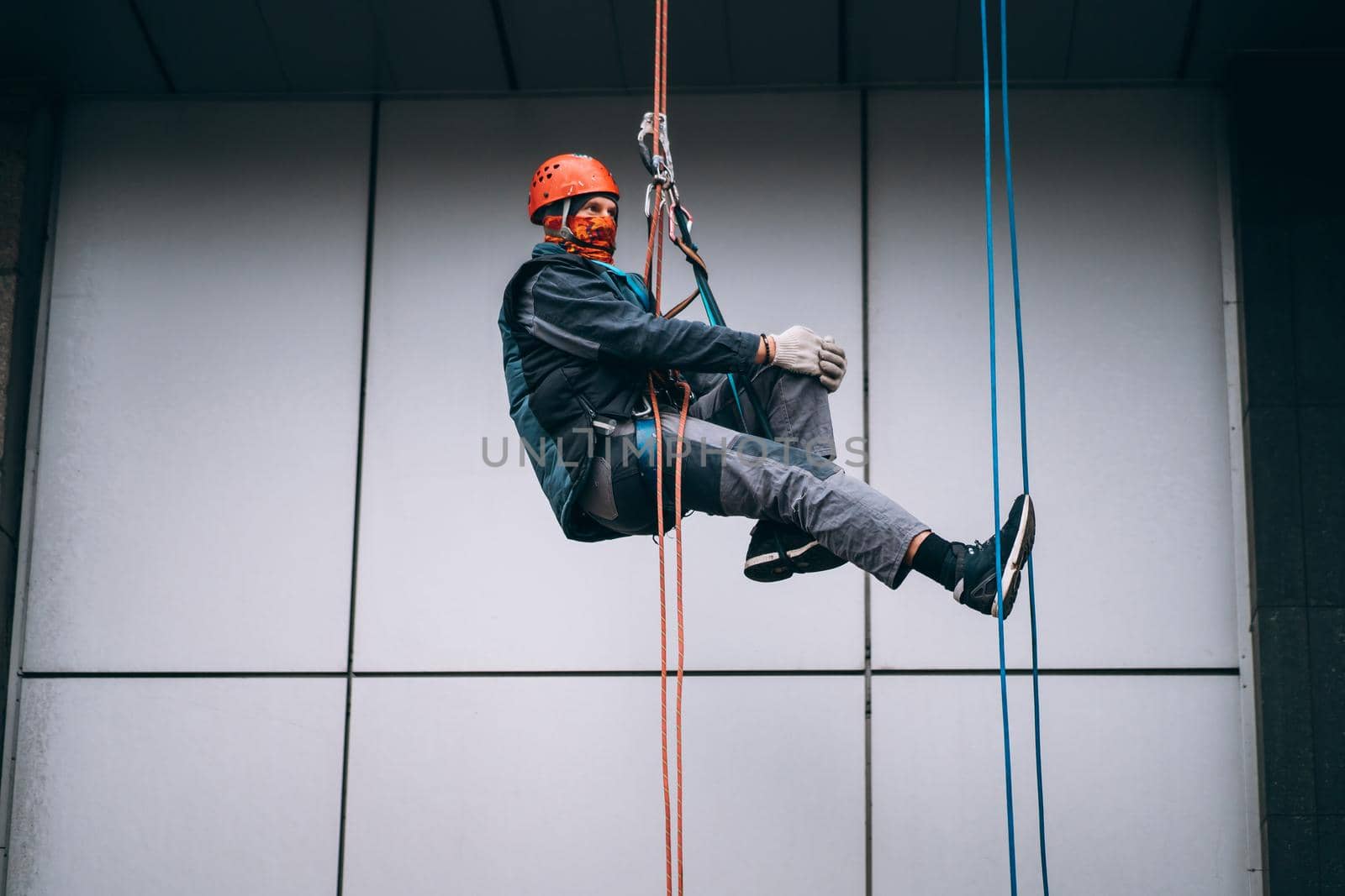 Industrial climber in uniform and helmet rises. Outdoor