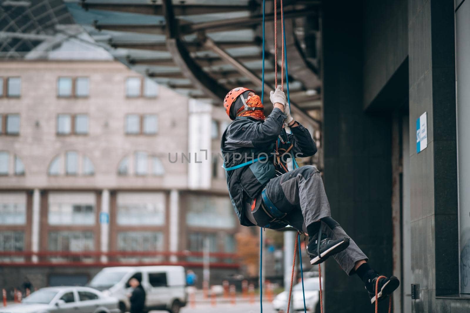 Industrial climber in uniform and helmet rises. Outdoor