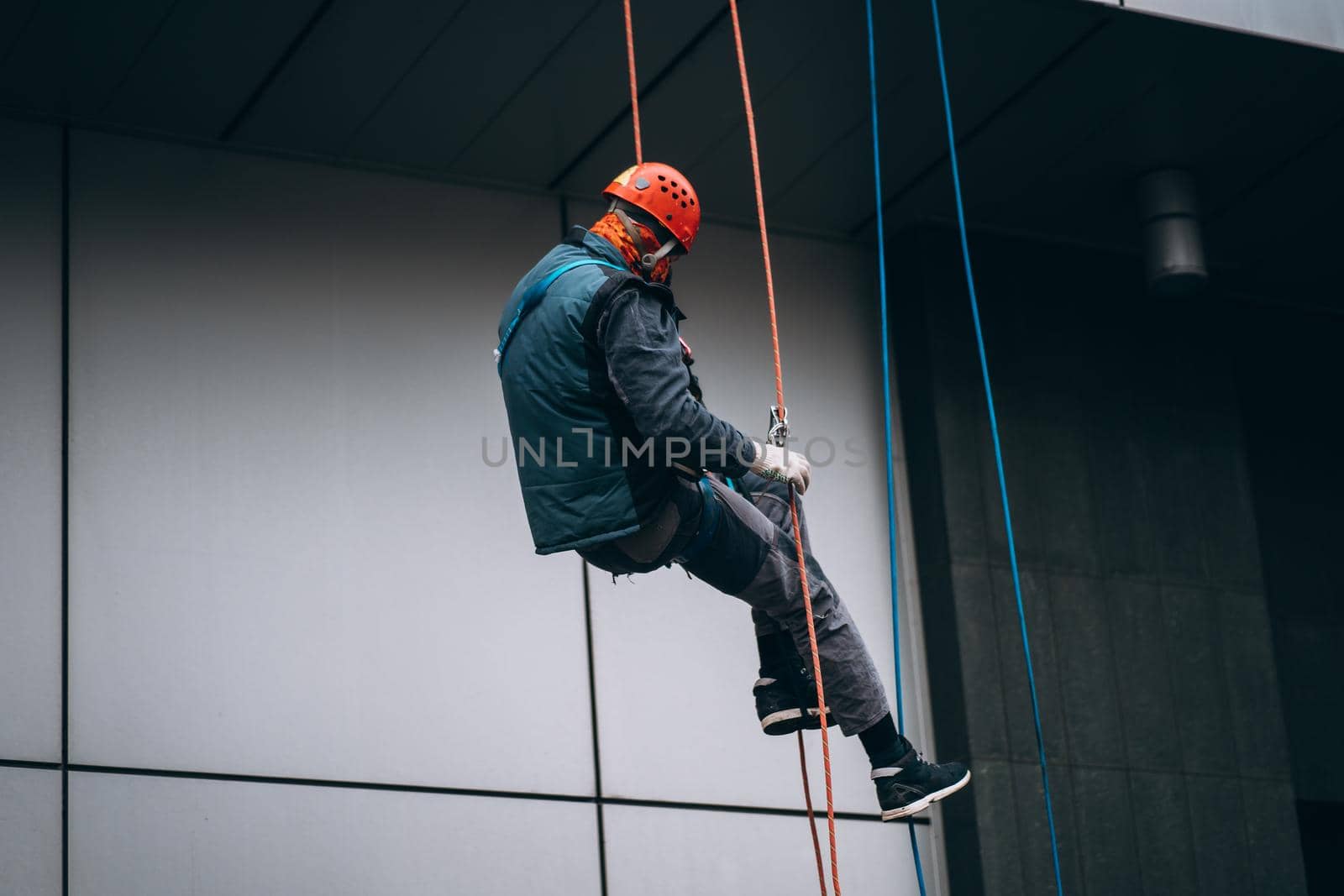 Industrial climber in uniform and helmet rises. Outdoor