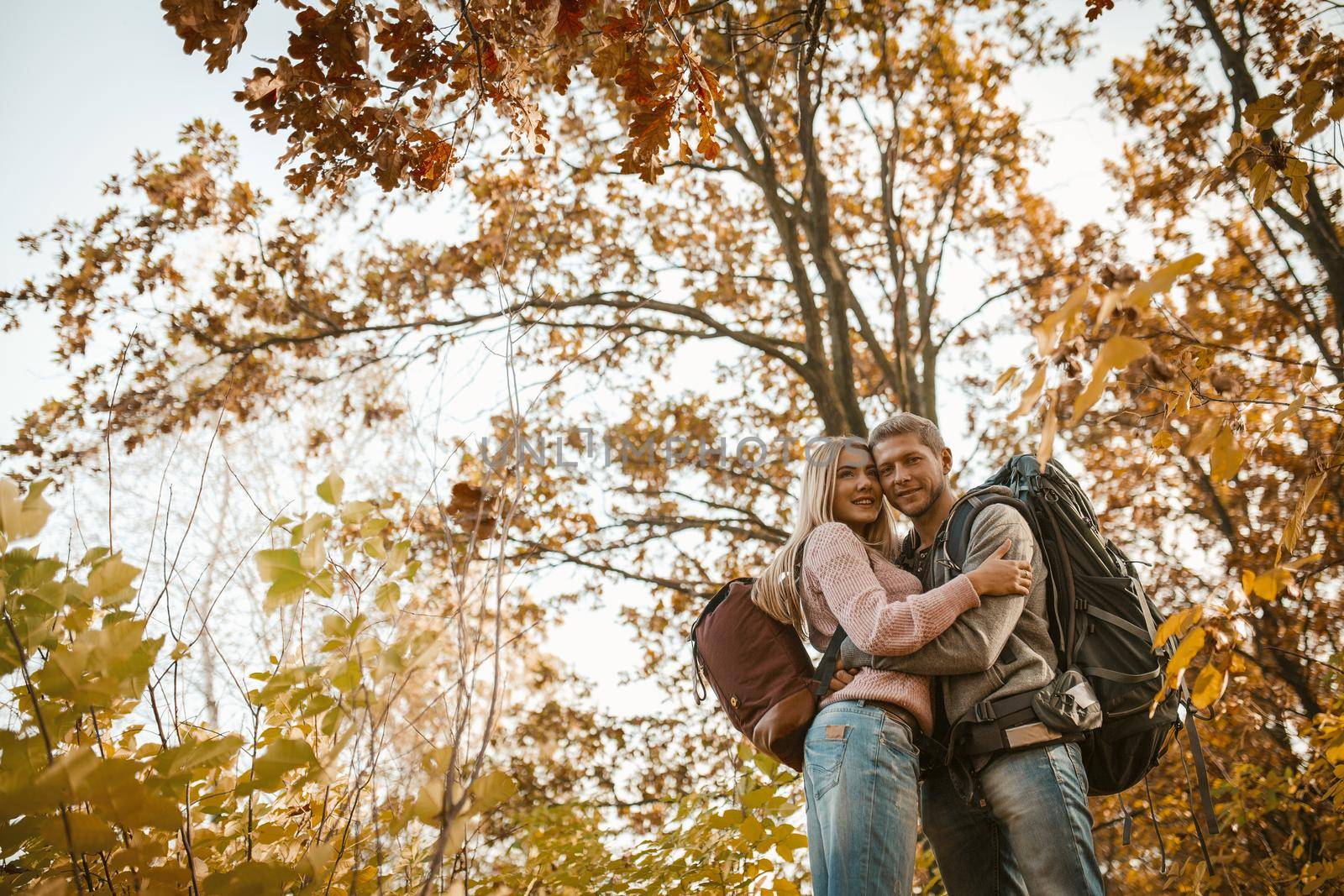 Man And Woman Hugs Standing In Autumn Forest by LipikStockMedia