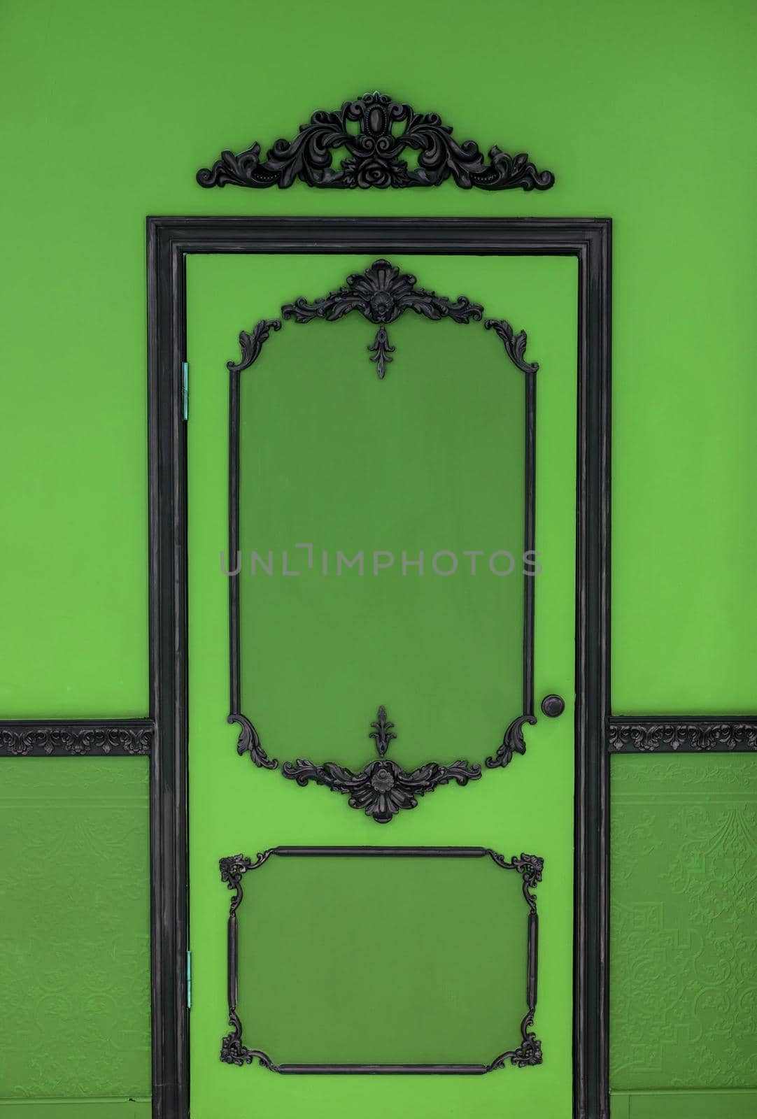 Old dramatic green doors on the background of the wall.