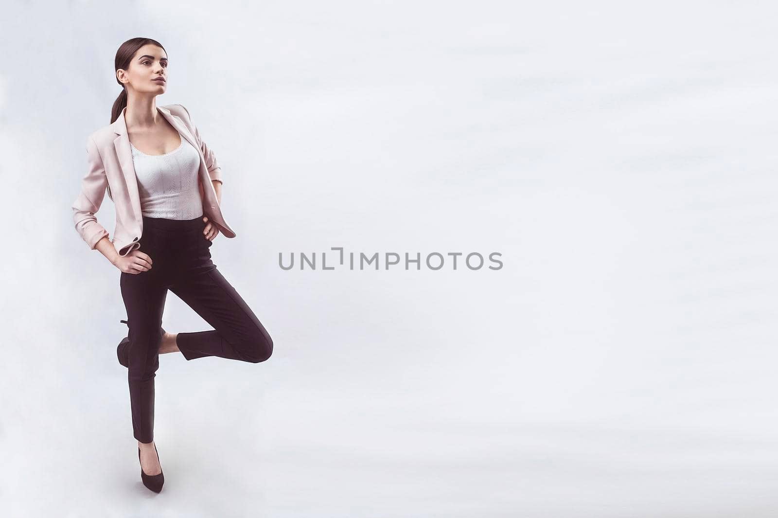 Portrait of nice young gorgeous woman on gray solid backgrounds. To a lots of copy space.