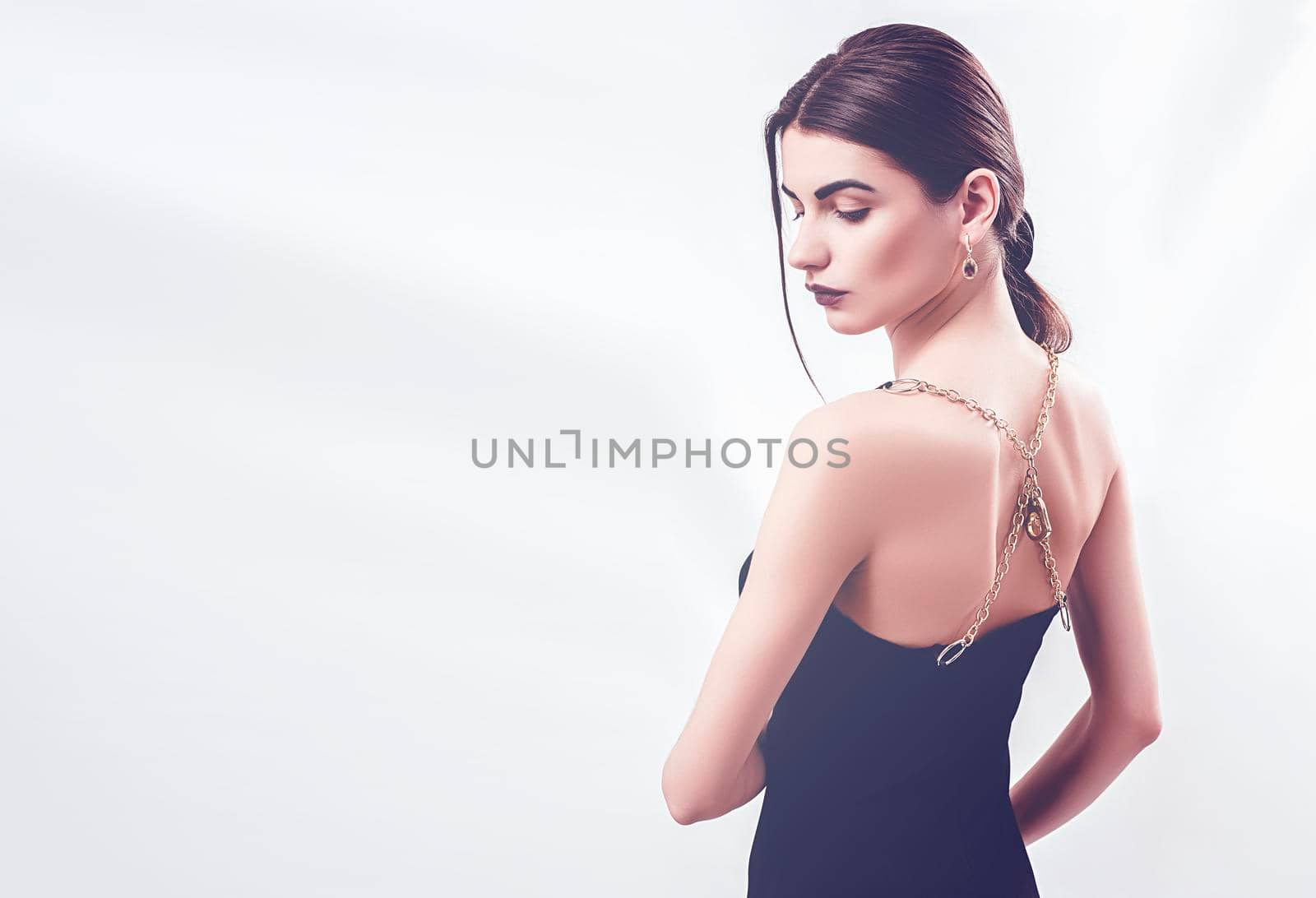 Portrait of nice young gorgeous woman on gray solid backgrounds. To a lots of copy space.