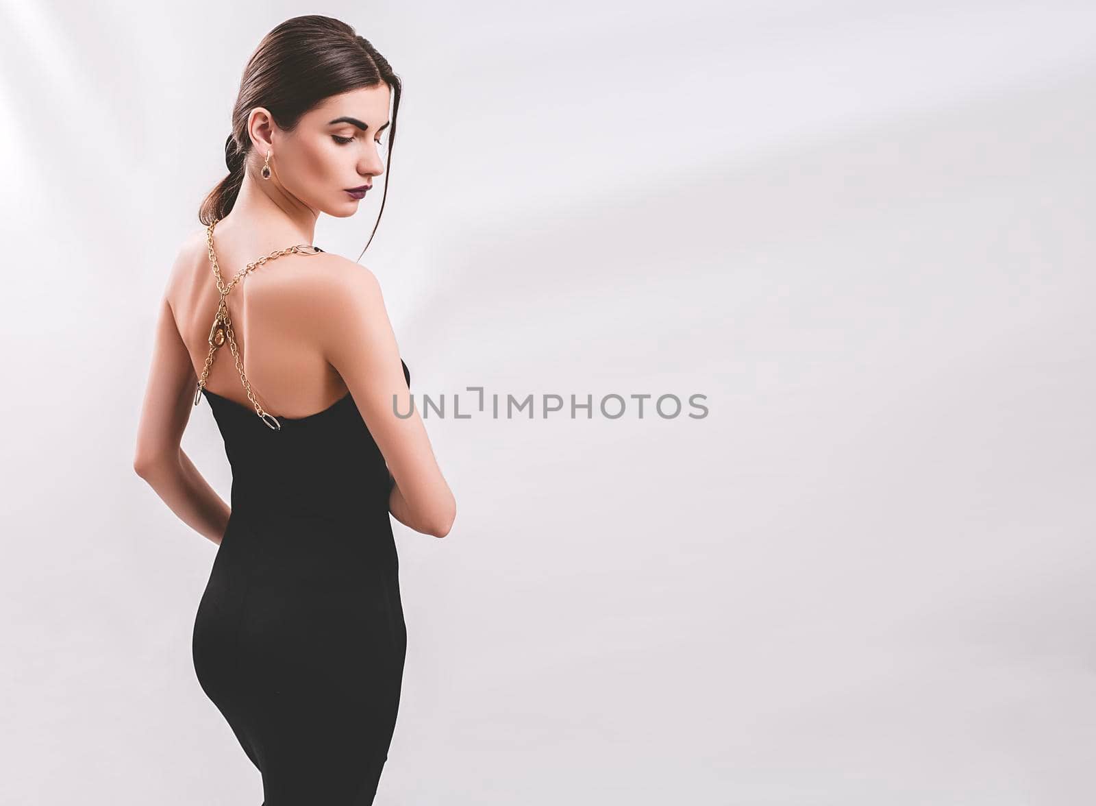 Portrait of nice young gorgeous woman on gray solid backgrounds. To a lots of copy space.