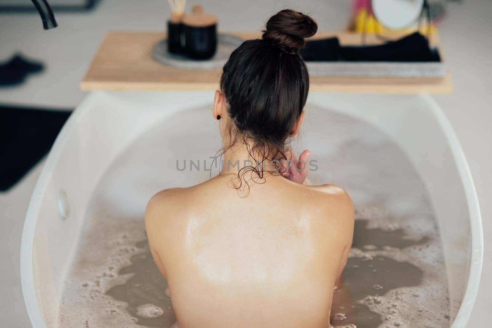Pretty young woman taking bath at home