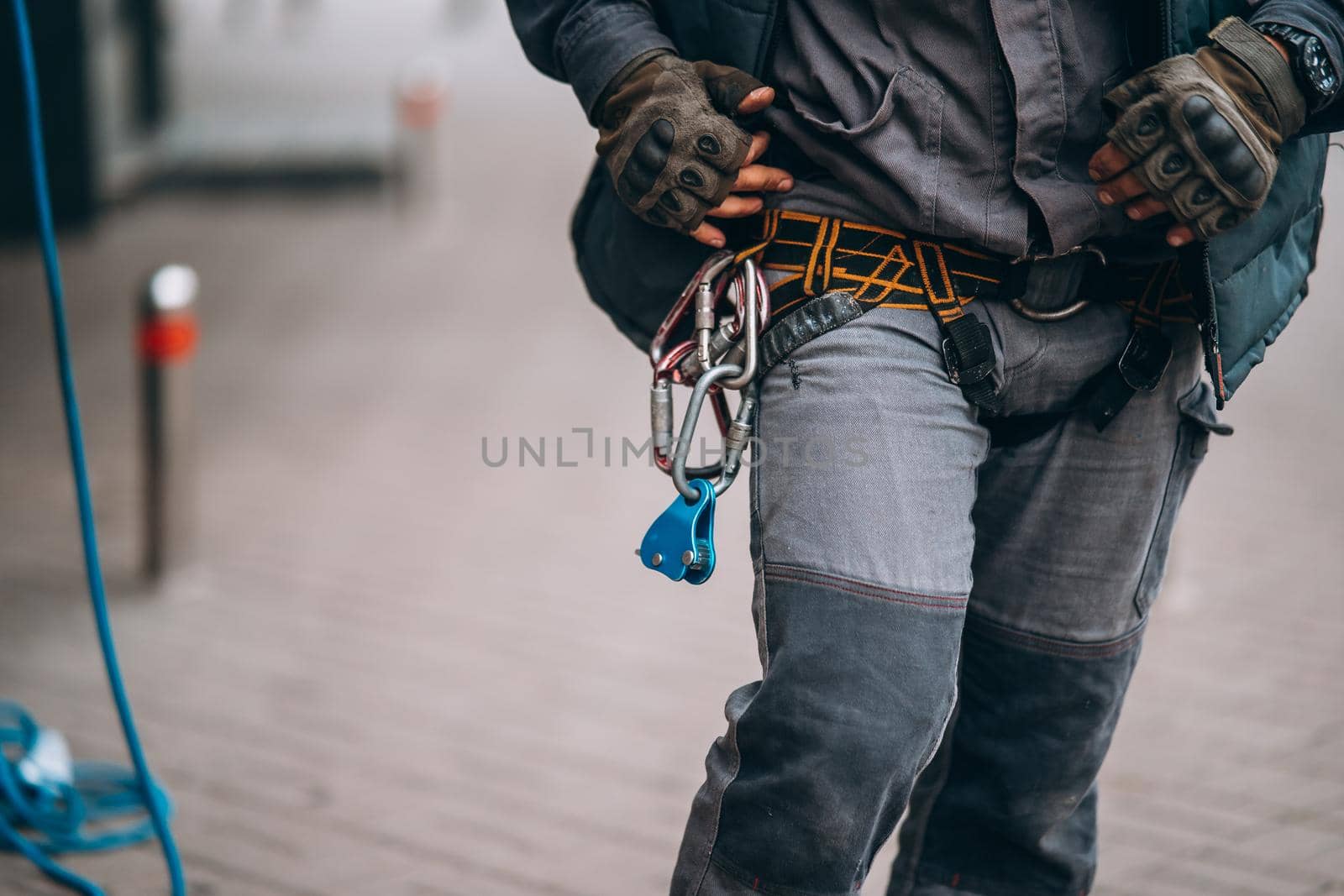 Worker climber preparing for work. Climber tightens the safety belt and check fixing and carbines