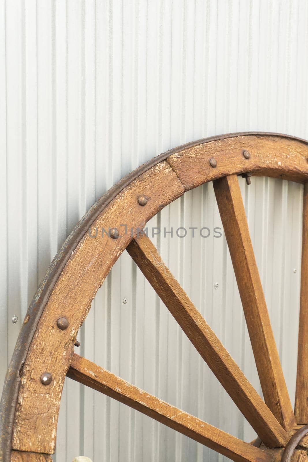 Antique wooden wheel on metallic background close up