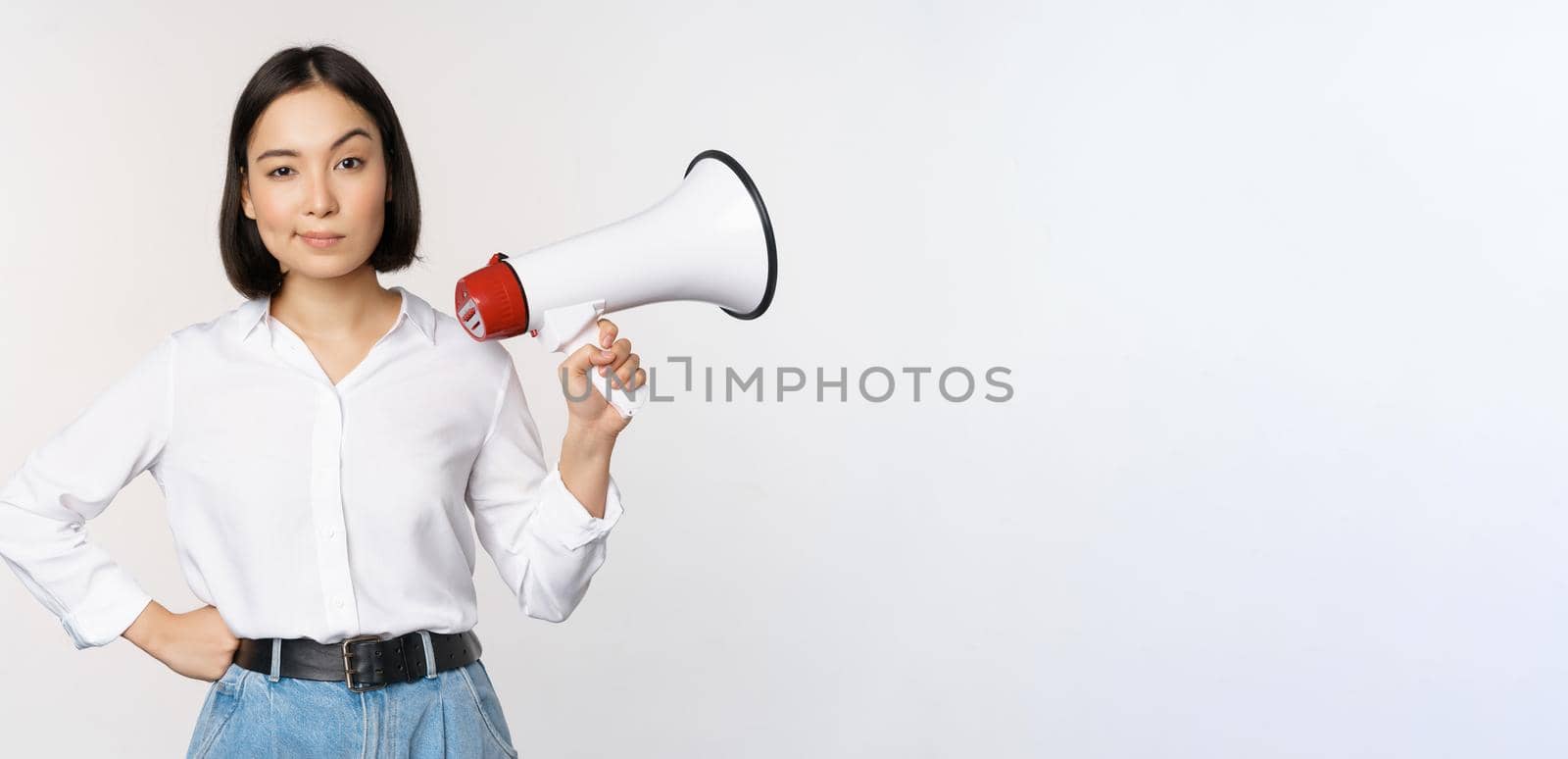 Image of modern asian woman with megaphone, making announcement, white background.