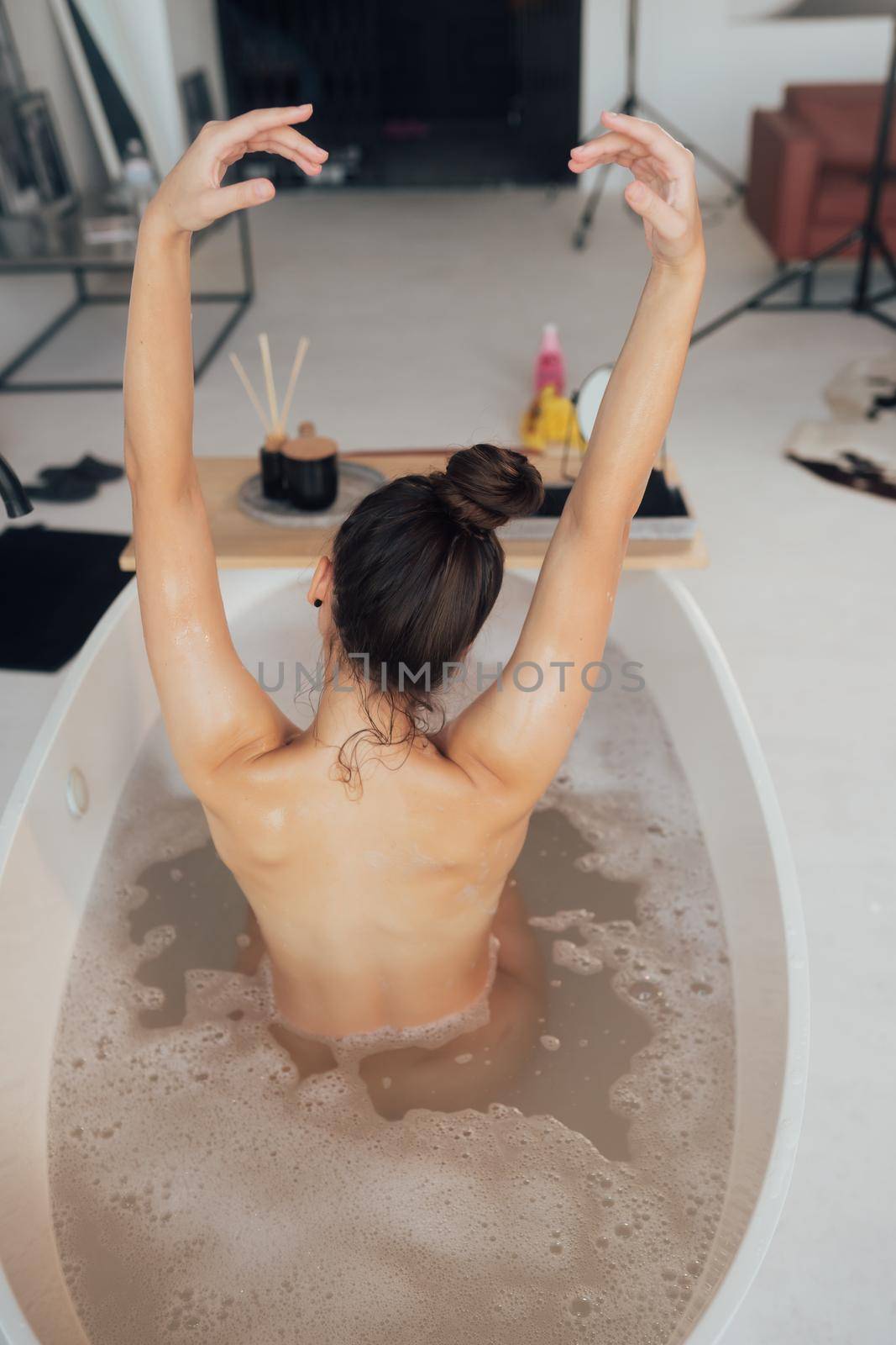 Pretty young woman taking bath at home
