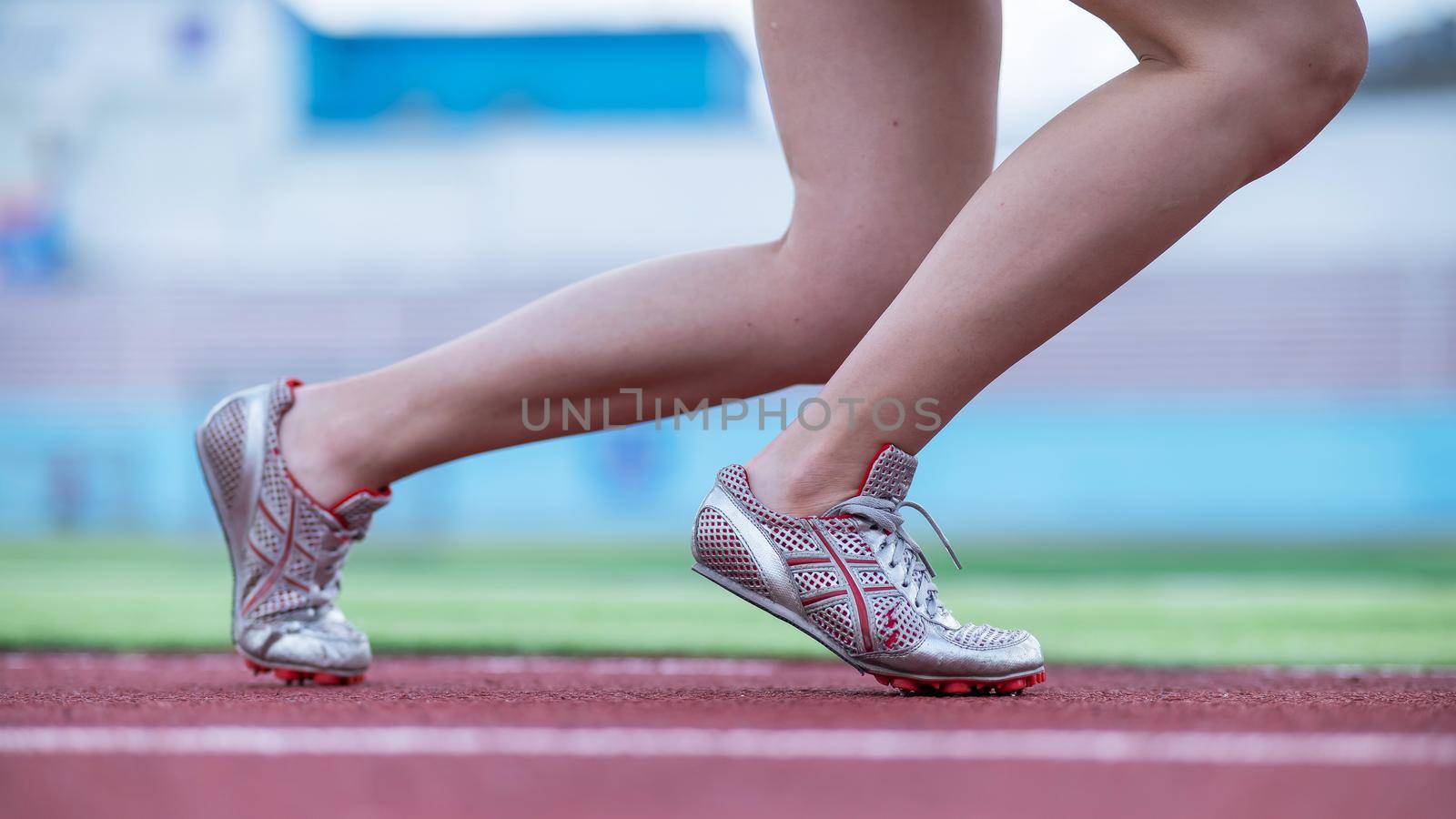 Close-up of female legs. The runner in the stadium