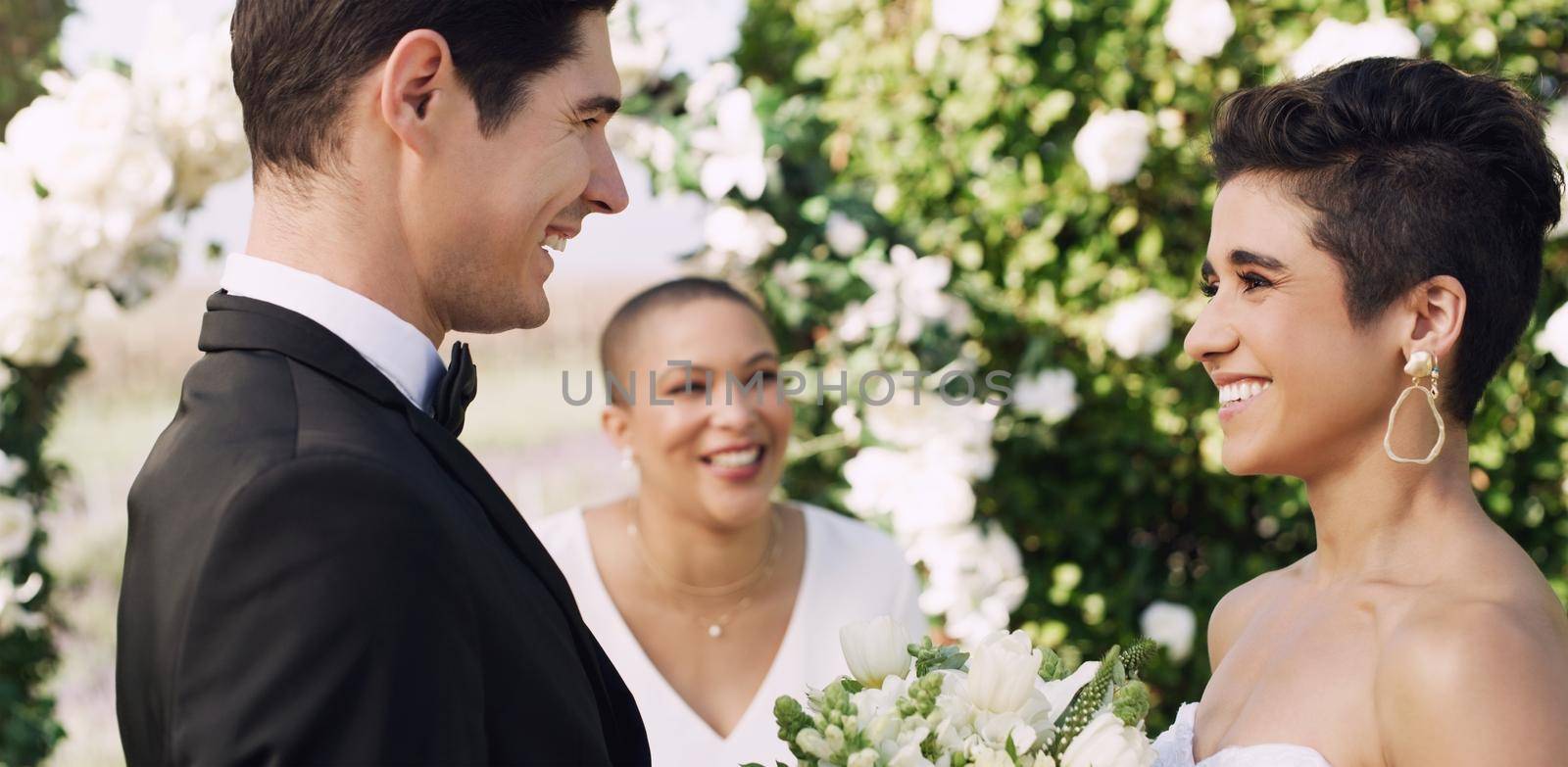 Im standing here as the luckiest man on earth. an affectionate young couple smiling at each other while saying their vows on their wedding day. by YuriArcurs