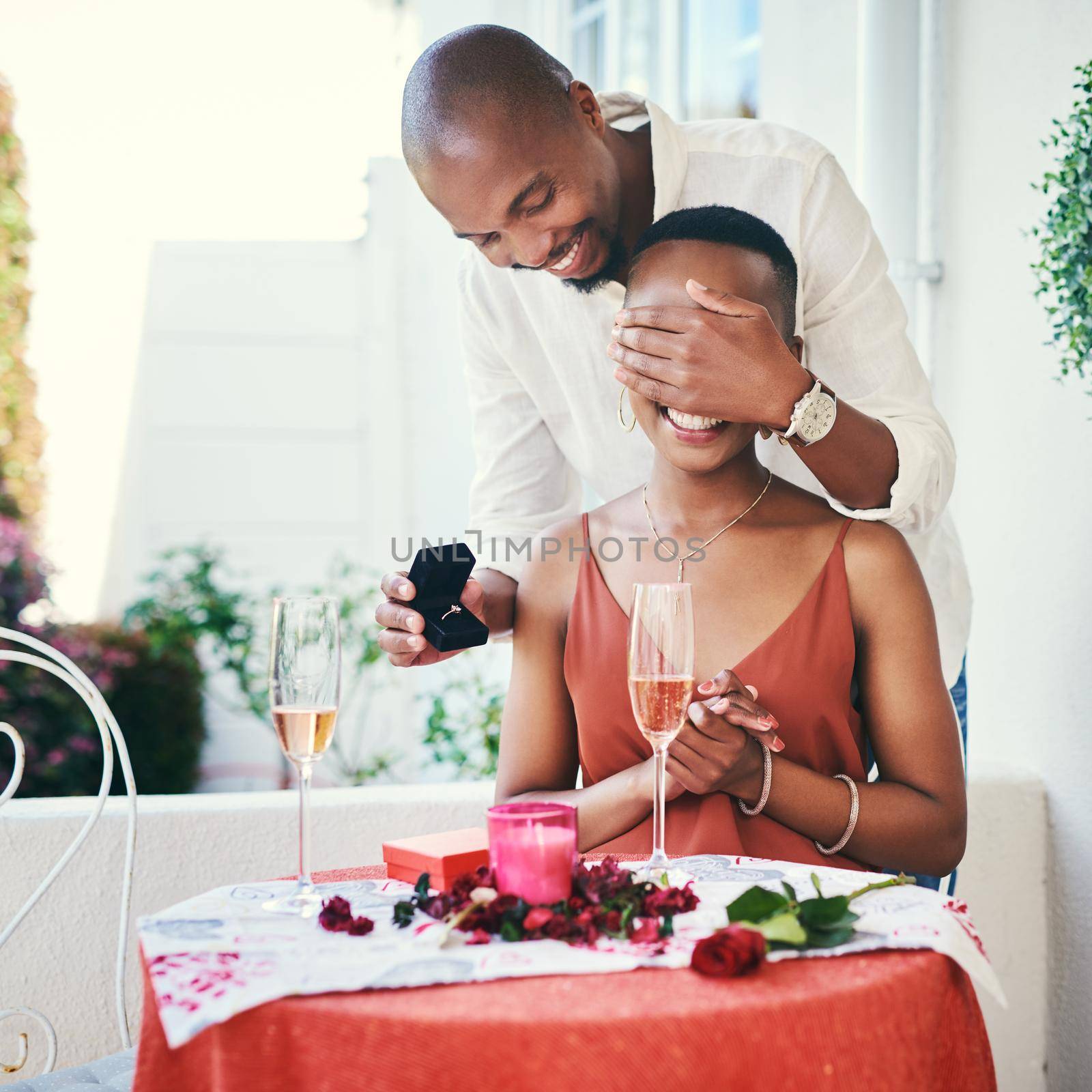 I have a surprise for you. a young man proposing to his his girlfriend on a romantic date