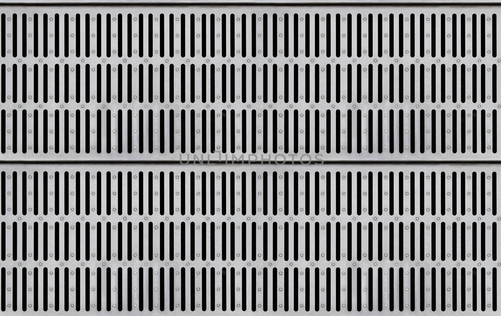 Seamless texture of silver-colored metal grate for water drain with long slits. Top view