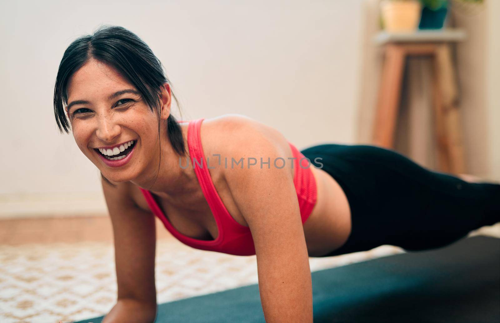 Activate those endorphins and start feeling good. Portrait of a happy young woman exercising at home. by YuriArcurs