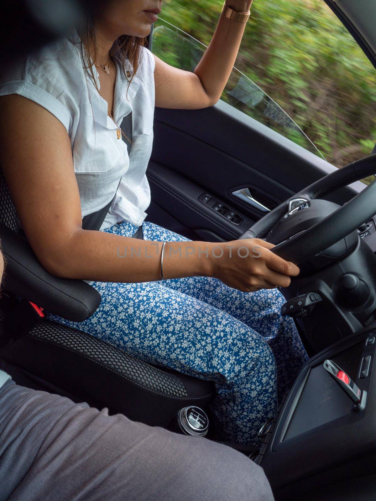 indian young woman driving a car suv in the mountain road a rainy cloudy day by verbano