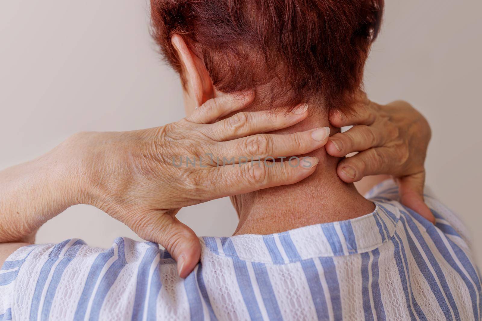 close-up, the hands of elderly woman massage her own neck Neurological diseases by Ramanouskaya