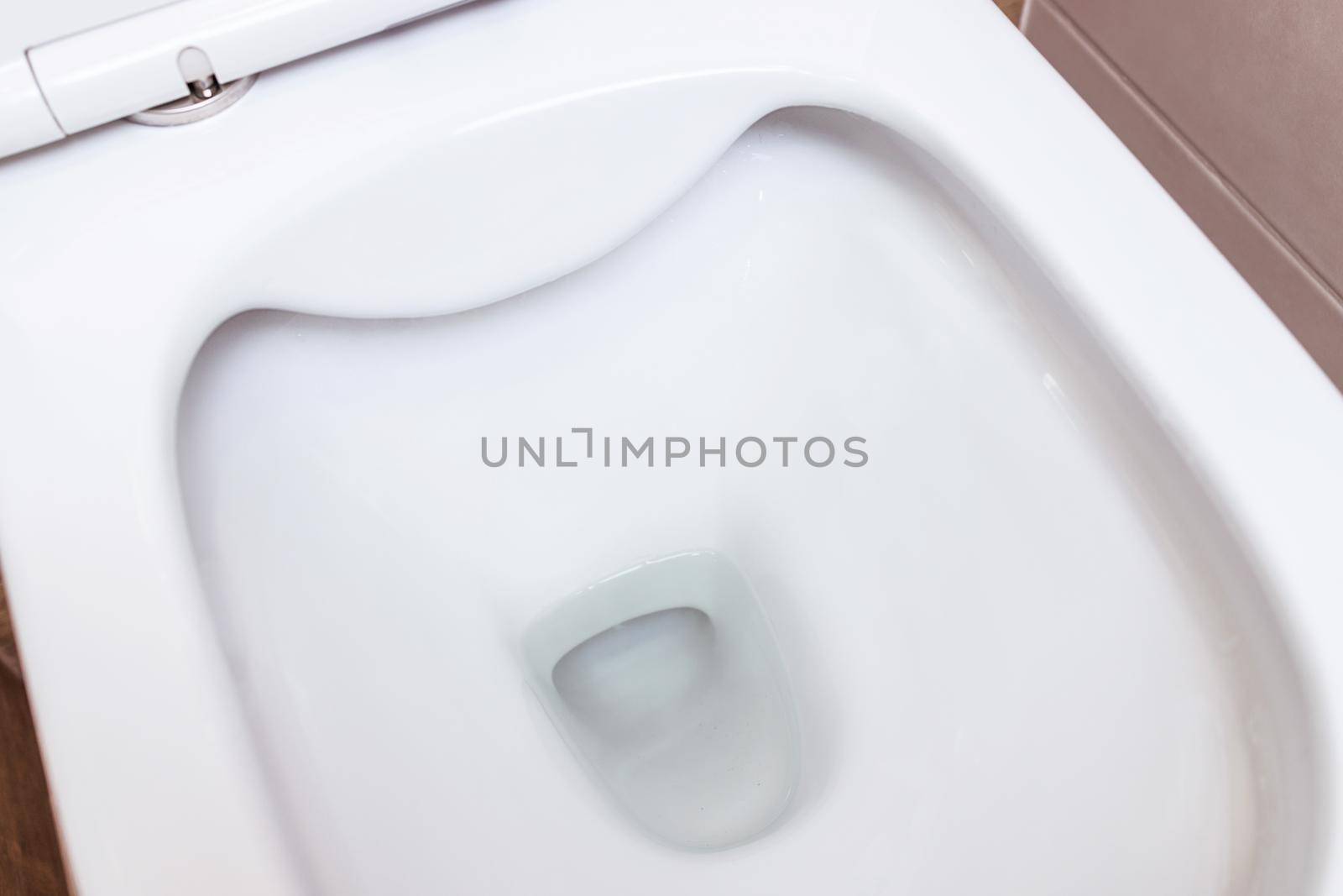Clean white ceramic toilet bowl in the bathroom toilet room. Open toilet with lid. Plumbing, mockup, design template for interior, cleaning, hygiene concept. View from above, flat lay. Bathroom interior