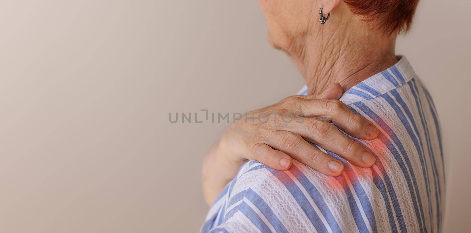 Sharp pain in the neck and shoulders in an old woman. Close-up of wrinkled hands rubbing their neck-collar area. neurological diseases. Medicine concept