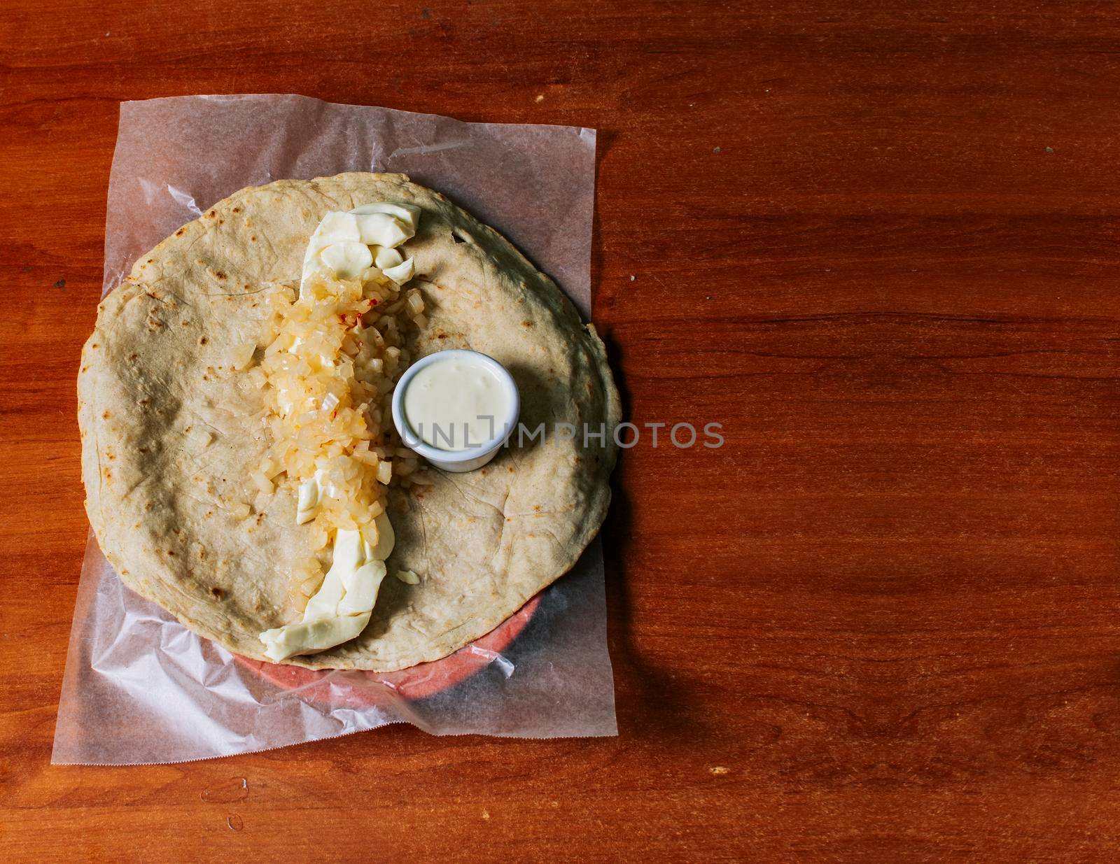 Traditional Nicaraguan Quesillo served on wooden table with copy space. Top view of Nicaraguan Quesillo served on wooden table. Traditional Nicaraguan Quesillo served on wooden table