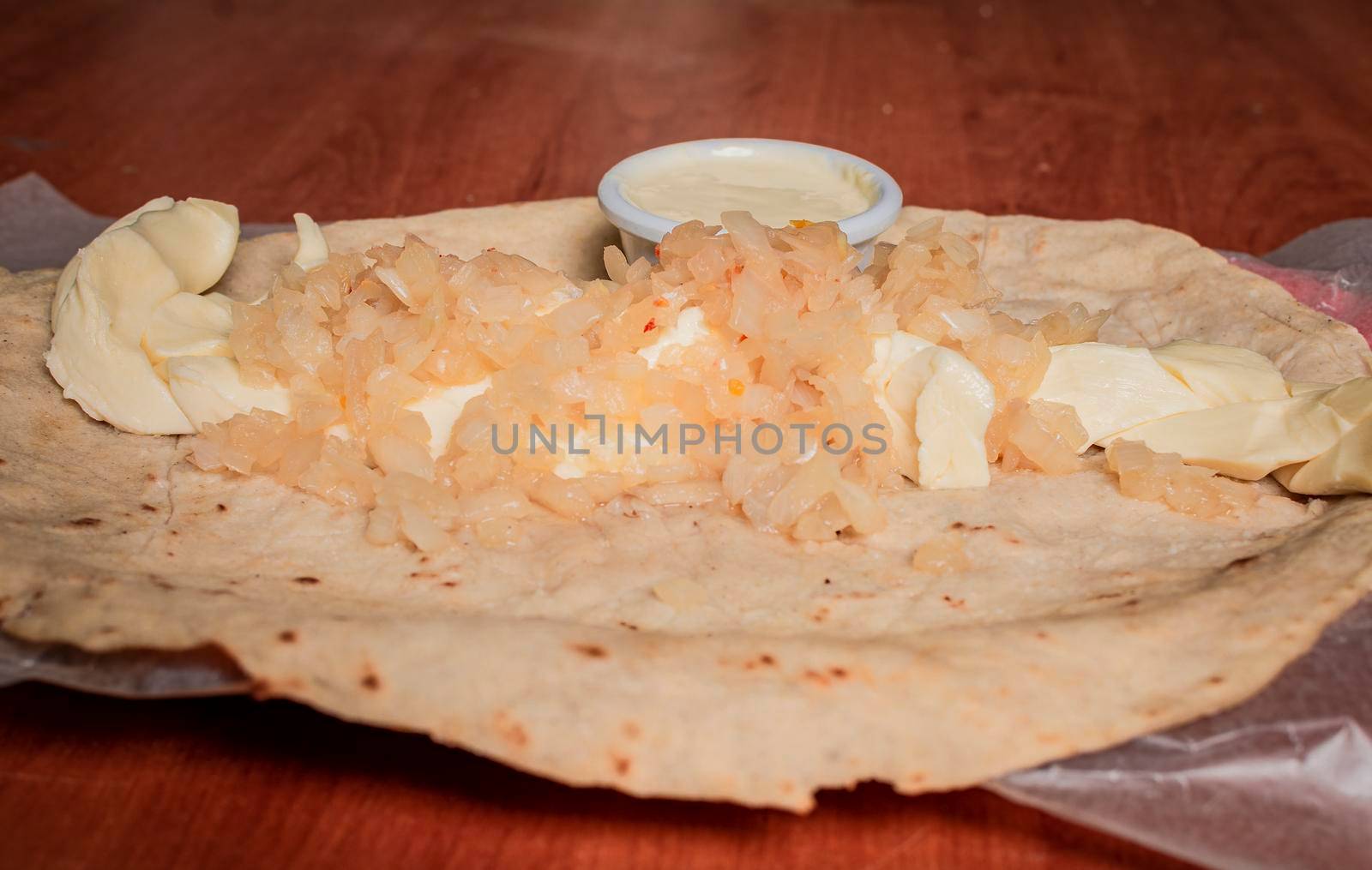 Close up of Nicaraguan Quesillo served on wooden table. Top view of Nicaraguan Quesillo served on wooden table. Traditional Nicaraguan Quesillo served on wooden table by isaiphoto